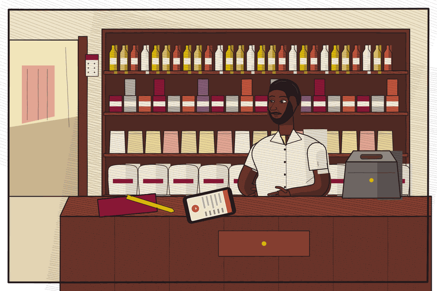 A shopkeeper in his shop, behind his counter.